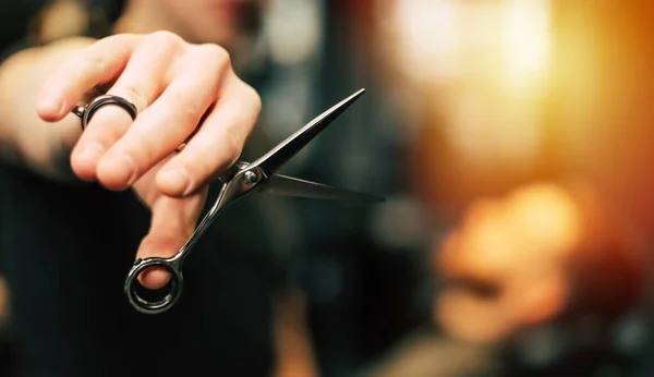hairdresser cutting scissors on the background of the barber shop