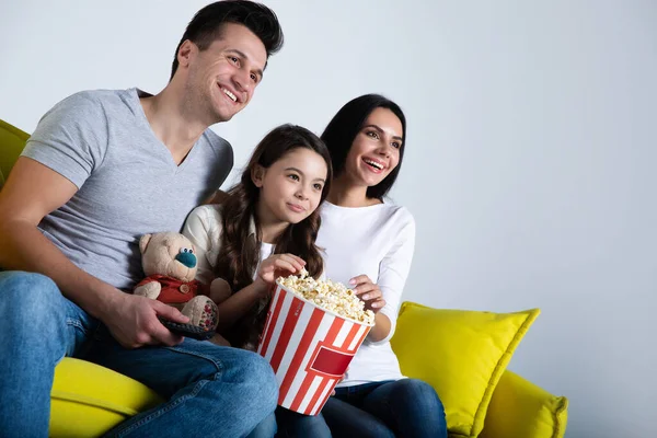 Gelukkig Jong Gezin Kijken Thuis Met Popcorn Zitten Gele Bank — Stockfoto
