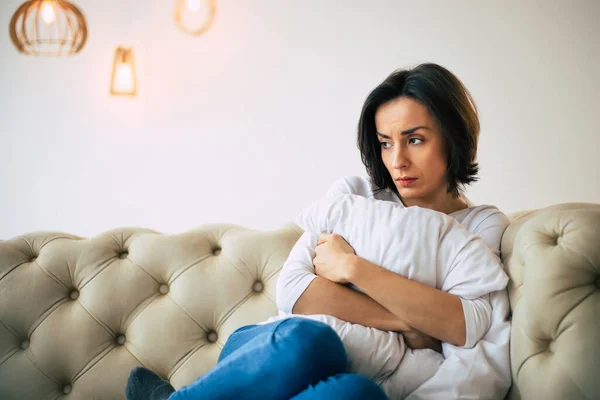 Unbehagen Schöne Traurige Frau Sitzt Auf Einem Sofa Umarmt Ein — Stockfoto