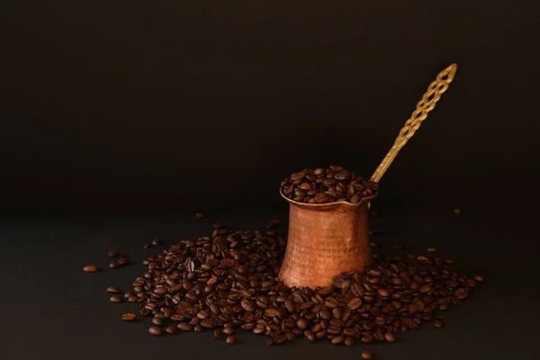 Ziarna kawy i dzbanek do kawy na ciemnym tle — Zdjęcie stockowe