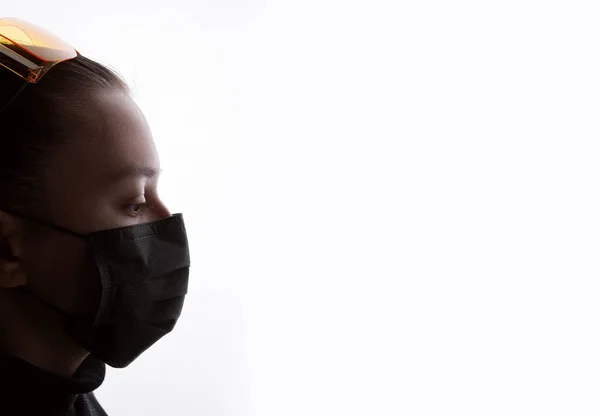 Young woman in protective respirator and glasses. Female wearing medical mask. Free space for text. White background. Healthcare, personal protection, virus, air pollution concept