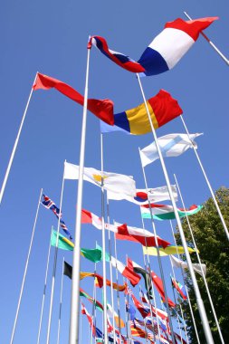 Yüksek direklere ülke bayrakları sallayarak