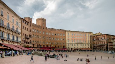 Turistler Siena, İtalya Piazza del Campo kare tadını çıkarın. Siena'nın tarihi merkezini Unesco tarafından dünya mirası ilan edildi.
