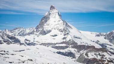 İsviçre 'nin Zermatt şehrinde beyaz kar ve mavi gökyüzü ile Matterhorn Dağı
