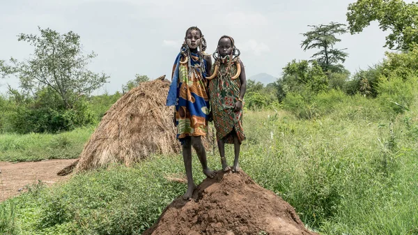 Dos chicas de la tribu Mursi de Etiopía. Las mujeres de la tribu Mursi tienen una placa labial y adornos de hierro. — Foto de Stock