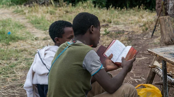 Pellegrino non identificato che legge la Bibbia in una delle antiche chiese rupestri di Lalibela — Foto Stock