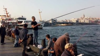 Türkiye - Ekim 2018: Eminonu 'da balıkçılar balık tutarken, insanlar Galata Köprüsü yakınlarındaki boğazı izlemek için oturuyorlar, Eminonu