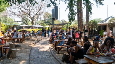 Fourways Farmers Market 'te sahnede şarkı söyleyen sanatçı insanların yediği ve sosyalleştiği, Johannesburg, Güney Afrika