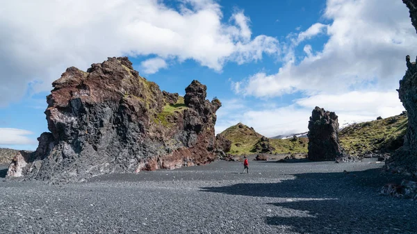 Άγνωστος άνθρωπος που περπατά σε ηφαιστειακά πετρώματα λάβας στην παραλία Djupalonssandur στη χερσόνησο Snaefellsnes στη Δυτική Ισλανδία — Φωτογραφία Αρχείου