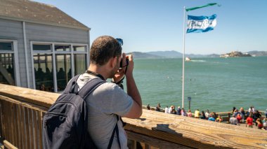 39. rıhtımda duran Alcatraz İzlanda 'nın fotoğrafını çeken balıkçı, San Francisco, California, Usa