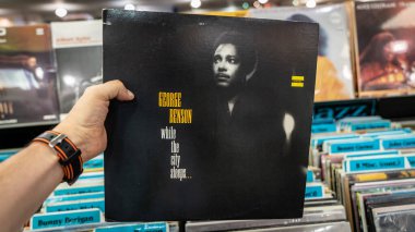 Adamın elinde George Benson, San Francisco, Usa 'nın retro stil vinil plağı var.