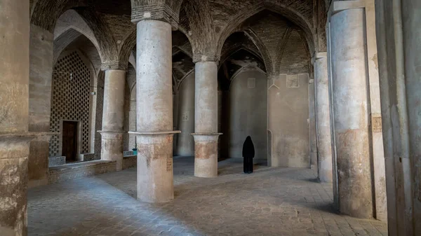 Mulher iraniana não identificada em vestido preto hijab andando ao longo das antigas colunas da Mesquita Jameh de Isfahan, Irã — Fotografia de Stock