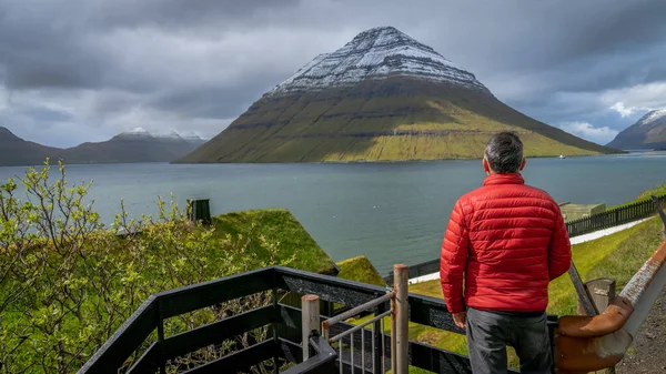 Ongeïdentificeerde man met uitzicht op het landschap van de Faeröer, Denemarken — Stockfoto