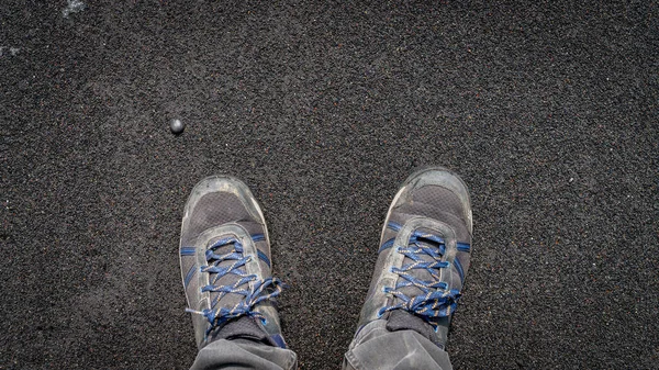 Shoes on volcanic black sand formation from black sand beach of Iceland