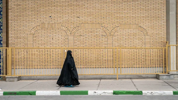 Неопознанная иранская женщина, идущая по улице в священном городе Кум, Иран — стоковое фото