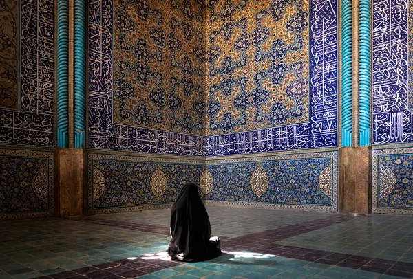 Azonosítatlan iráni nő csadorban imádkozik Sheikh Lotfollah mecset csempe a falakon, Isfahan, Irán — Stock Fotó