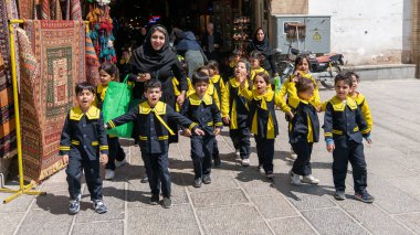 İran, İsfahan 'da bir sokakta öğretmenleriyle yürüyen okul çocukları.