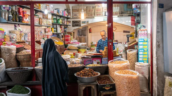 Mujer comprando bocadillos en una tienda en el Gran Bazar de Isfahán, Irán — Foto de Stock