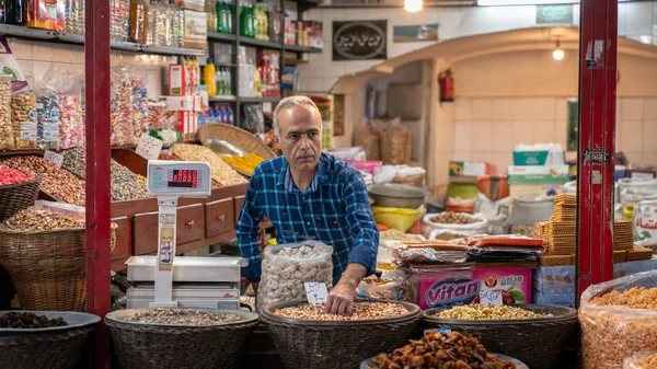 Hombre iraní vendiendo bocadillos en su tienda en el Gran Bazar de Isfahán, Irán — Foto de Stock