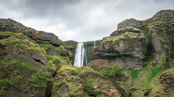 Wodospad Gljufrabui z niezidentyfikowanymi turystami w pobliżu w Islandii — Zdjęcie stockowe