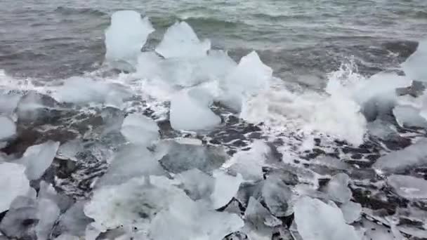 アイスランドのジョクルサロン氷河ラグーンの融解氷山から海岸の氷の破片 地球温暖化と気候変動の概念 — ストック動画