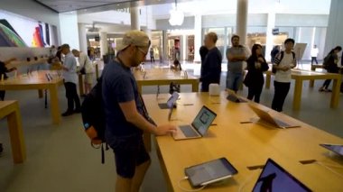 San Francisco, California, USA - August 2019: Young man examining the MacBook laptop computer at Apple Store in Union Square