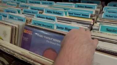 San Francisco, California, Usa, Ağustos 2019: Bir müzik dükkanında plak kayıtlarına bakan adam. Vinil turntable plaklı kutuların Retro biçimli videosu