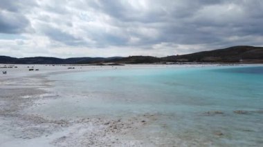 Salda Lake, Burdur, Türkiye - Ekim 2019: Salda Gölü 'nde yürüyen turistler. Salda Gölü Türkiye 'nin Maldivleri olarak ünlendi