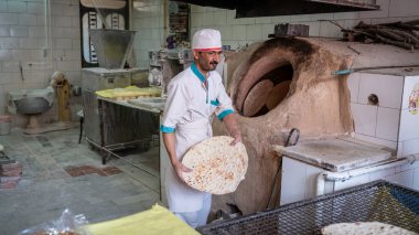 Abyaneh, İran - Mayıs 2019: Geleneksel fırında ekmek yapan adam