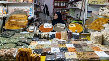 İsfahan, İran - Mayıs 2019: Tarihi pazar olan İsfahan Büyük Çarşısı 'nda çeşitli otlar ve baharatlar satan Iraklı kadın