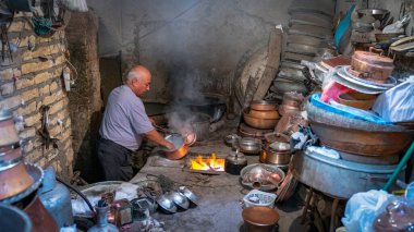 Yazd, İran - Mayıs 2019: Bakır tezgahında bakır tencereyle çalışan İranlı adam