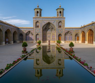 Şiraz, İran - Mayıs 2019: Avluda dikilen kadın Şiraz 'da Nasir al-Mulk Camii havuzu ile