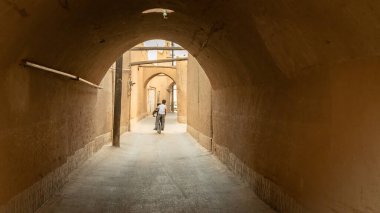 Yazd, İran - Mayıs 2019: Yazd 'ın dar sokaklarında bisiklet süren çocuk