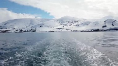 Akdamar adası, Van, Türkiye - Şubat 2020: Akdamar adasına giden tekneden Akdamar kilisesine doğru giden Van şehrinin kar altında görüntüsü.
