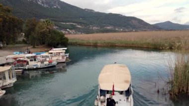 Akyaka, Mugla - Mart 2020: Popüler Akyaka kasabası, tur botları ve nehir kenarında yürüyen insanlarla. Akyaka, Türkiye 'nin güneybatısında, Mugla ilinin bir kıyı kentidir..