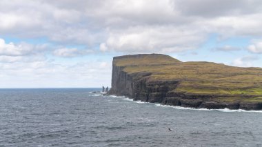 Risin ve Kellingin, Danimarka, Avrupa 'daki Faroe Adaları' ndaki Streymoy 'da dalgaların vurduğu Tjornuvik körfezinden görüldüğü gibi kayalar.