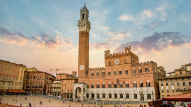 Siena, Toscana, İtalya - Eylül 2014: Torre del Mangia 'nın çan kulesine bakan şaşırtıcı gün batımı