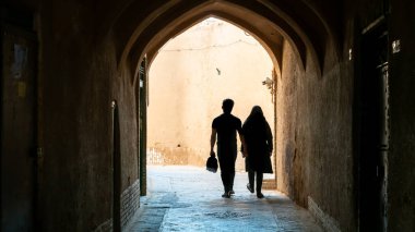İran 'ın Yazd şehrinin dar sokaklarında yürüyen kimliği belirsiz bir çift.