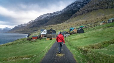 Faroe Adaları 'ndaki dramatik yolda yürüyen kimliği belirsiz bir adam.