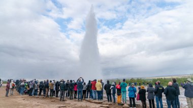 Strokkur, İzlanda - Mayıs 2019: İzlanda 'daki Strokkur gayzeri turistler izlerken patlıyor