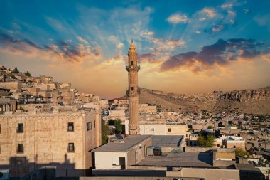 Mardin, Turkey - January 2020: Sehidiye mosque and its minaret with old Mardin cityscape clipart