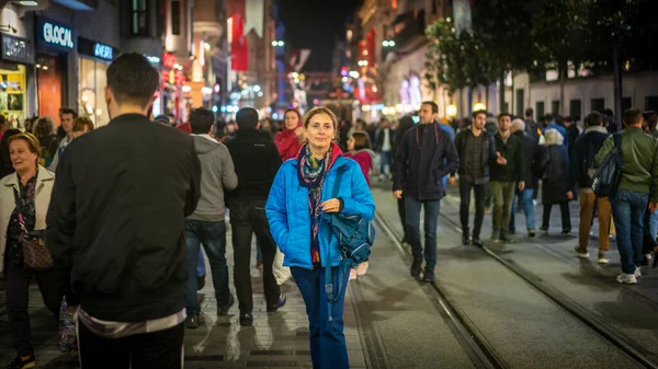 İstanbul, Türkiye - Kasım 2019: İstanbul şehir hayatı, Taksim Meydanı istiklal Caddesi 'nde kalabalık arasında tek başına yürüyen kadın. Fotoğraf hareketi bulanık ve bilerek ve orjinal olarak odak dışı