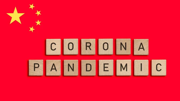 Corona pandemic written with wooden tiles over Chinese flag background. Respiratory syndrome coronavirus and Novel coronavirus 2019-nCoV. Virus Pandemic concept