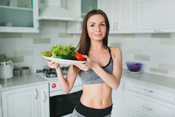 Giovane ragazza con insalata dopo l'allenamento — Foto Stock