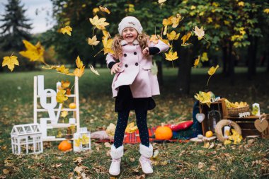 düşen yapraklar ile oynayan kız