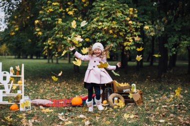 düşen yapraklar ile oynayan kız