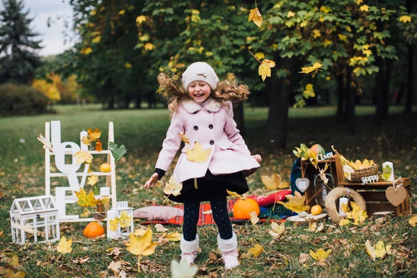 düşen yapraklar ile oynayan kız