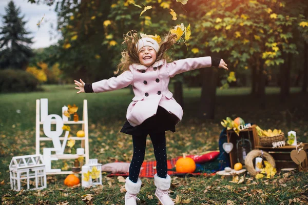 düşen yapraklar ile oynayan kız