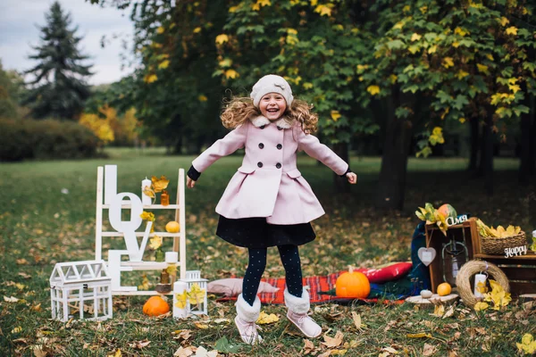 Menina brincando com folhas caídas — Fotografia de Stock