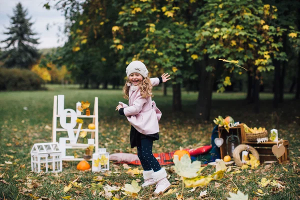 Dívka si hraje s spadaného listí — Stock fotografie